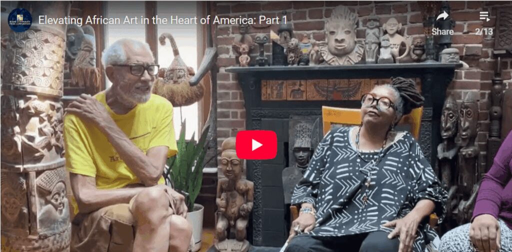 People discussing African art collection indoors.