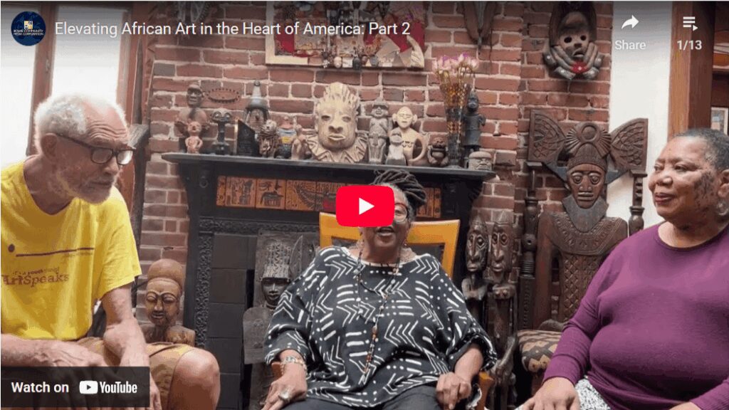 Three people discussing African art collection.